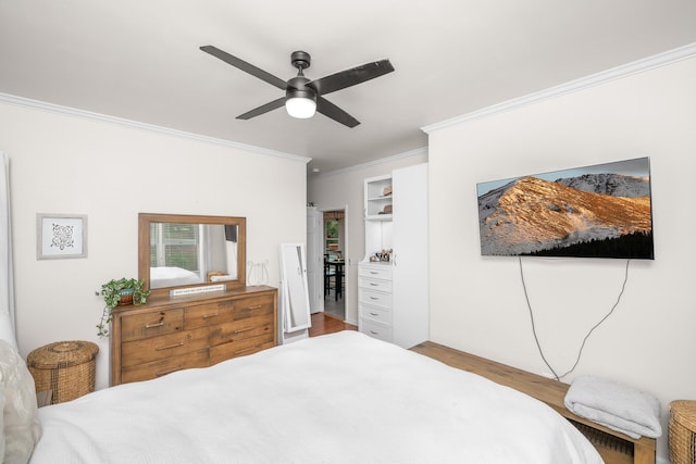 bedroom with ornamental molding, wood finished floors, and a ceiling fan