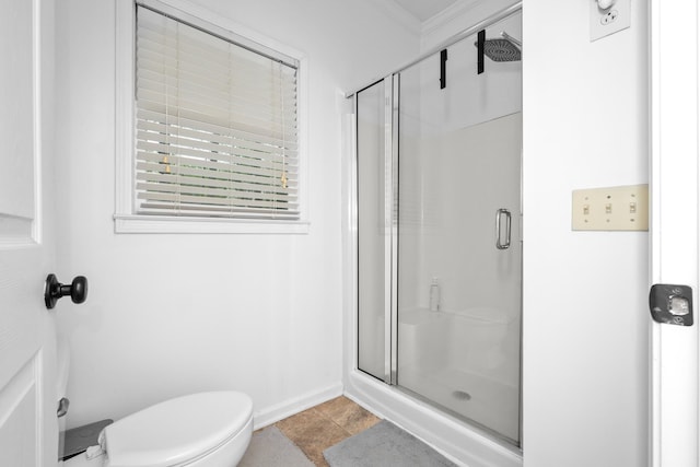 bathroom featuring toilet, a stall shower, and baseboards