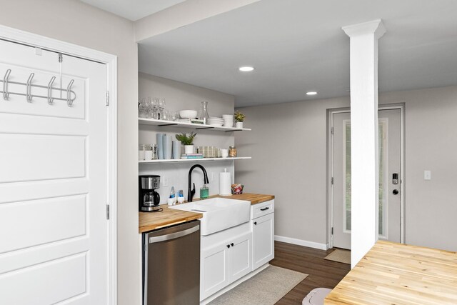 interior space featuring white cabinets, butcher block counters, dark wood finished floors, a sink, and stainless steel dishwasher
