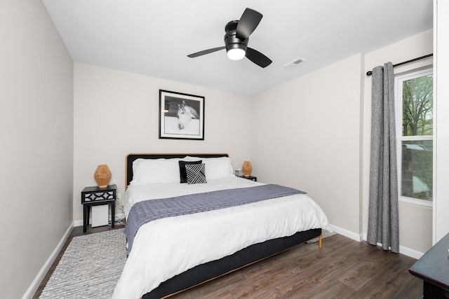 bedroom featuring a ceiling fan, dark wood-type flooring, baseboards, and visible vents