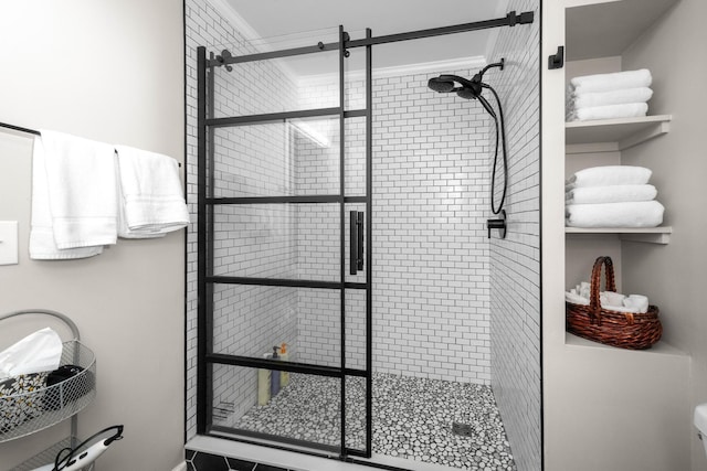 bathroom with toilet, ornamental molding, and a shower stall