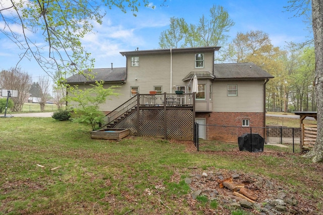 rear view of property featuring fence, stairway, a deck, and a lawn