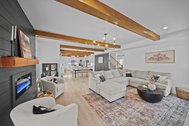 2046 Bluet, Woodruff, SC 29388 - living area featuring a large fireplace, a chandelier, wood finished floors, stairs, and beam ceiling