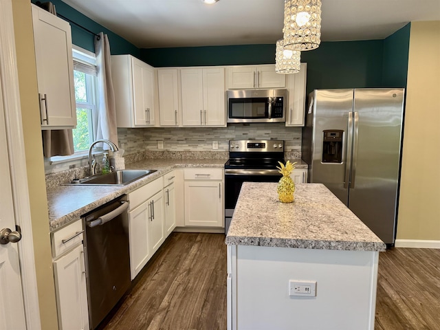 kitchen with a sink, light countertops, dark wood finished floors, stainless steel appliances, and a kitchen island