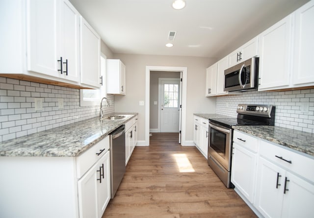 100 Winterhaven, Spartanburg, SC 29301 - kitchen with light wood-style flooring, white cabinetry, appliances with stainless steel finishes, a sink, and baseboards