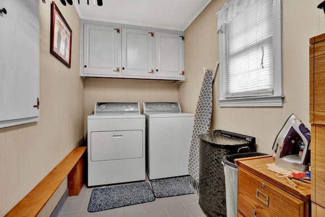 washroom with crown molding, washing machine and clothes dryer, cabinet space, and tile patterned floors