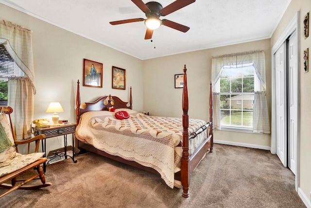 carpeted bedroom with crown molding, a closet, and baseboards