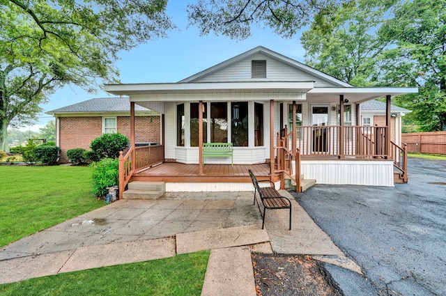view of front of home with a porch, a front lawn, and brick siding