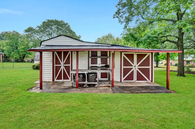 view of outdoor structure featuring fence and an outbuilding