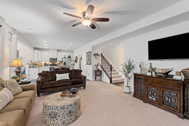 living room with recessed lighting, stairway, light carpet, and a ceiling fan