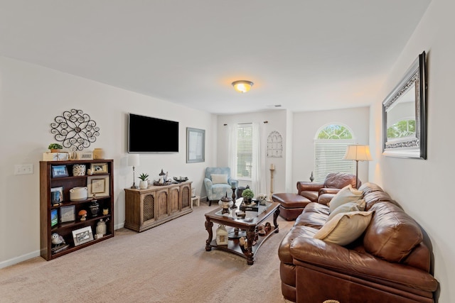 living area featuring light carpet and baseboards