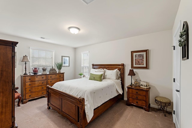bedroom with light carpet, visible vents, and baseboards