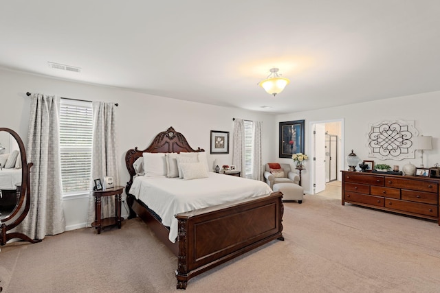 bedroom with light carpet, visible vents, and multiple windows