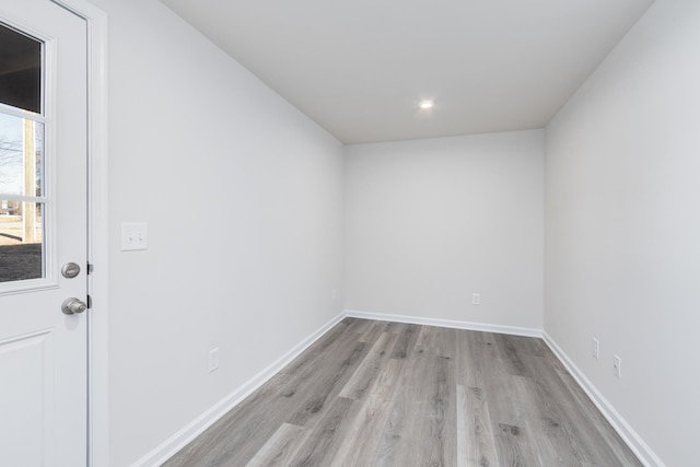 spare room with baseboards, light wood finished floors, and recessed lighting