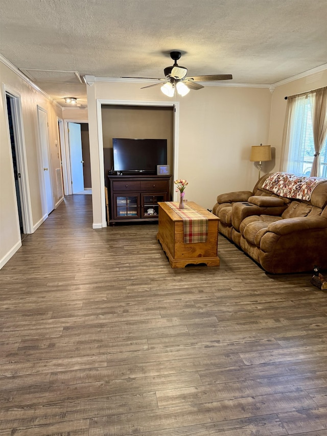 living area featuring ornamental molding, a textured ceiling, wood finished floors, ceiling fan, and baseboards