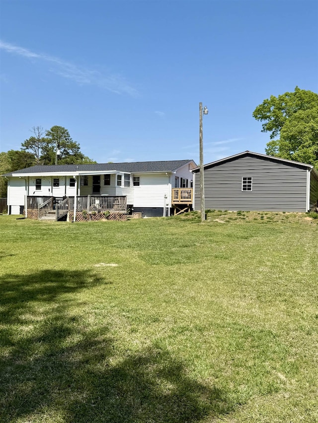 back of house featuring a wooden deck and a lawn