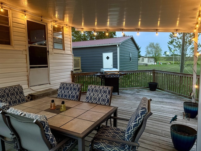 deck with a grill and outdoor dining area