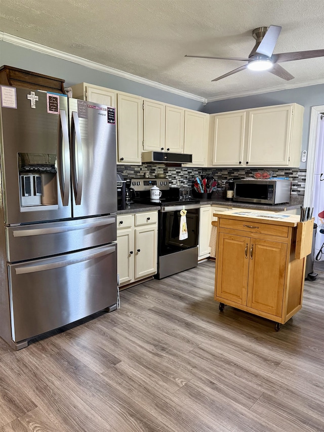 kitchen with stainless steel appliances, under cabinet range hood, a textured ceiling, backsplash, and crown molding