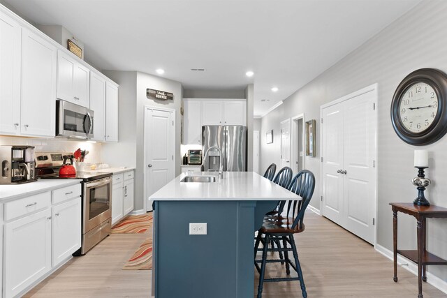 122 Aleppo, Greer, SC 29651 - kitchen with a kitchen bar, light wood-type flooring, white cabinets, appliances with stainless steel finishes, and a sink