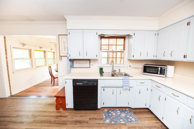 kitchen with stainless steel microwave, ornamental molding, light wood-style flooring, black dishwasher, and a sink