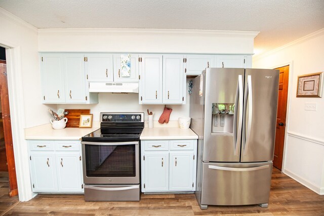 kitchen featuring crown molding, appliances with stainless steel finishes, light countertops, and under cabinet range hood