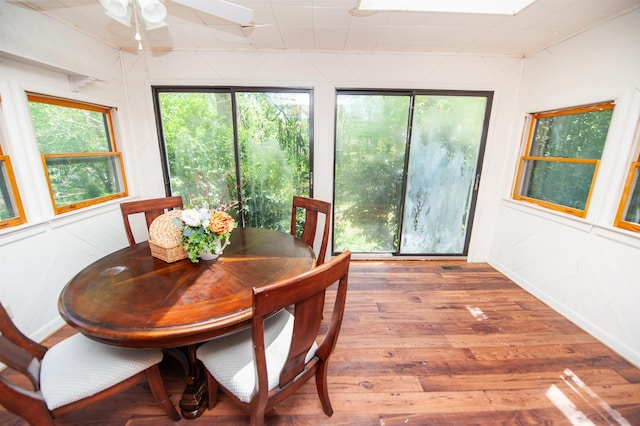 dining space with wood finished floors, ceiling fan, and baseboards