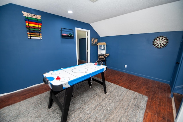 recreation room featuring baseboards, a textured ceiling, wood finished floors, and lofted ceiling