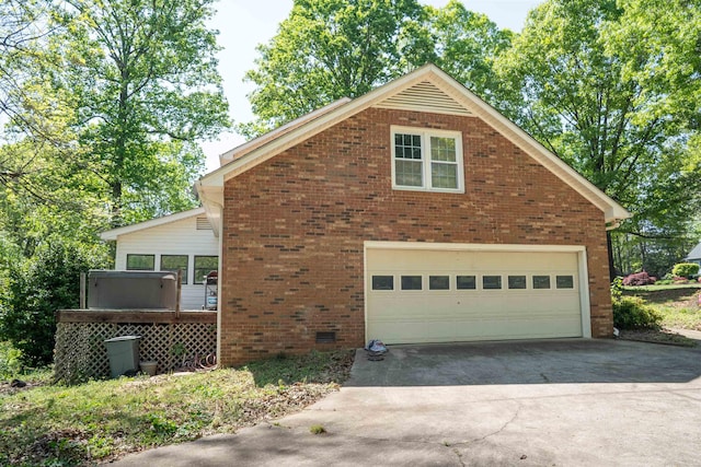 view of side of home with a garage, concrete driveway, and brick siding
