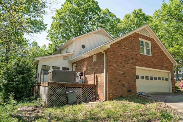 view of property exterior with concrete driveway, brick siding, and a deck