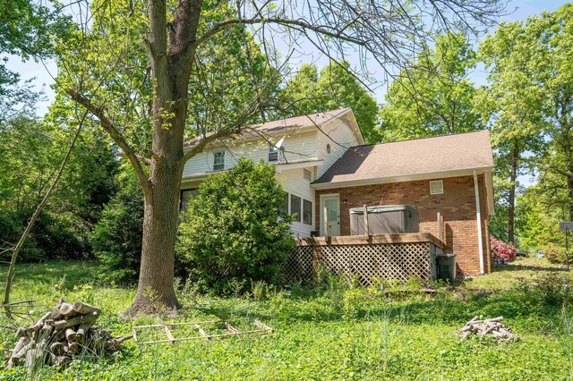rear view of house featuring a wooden deck and brick siding