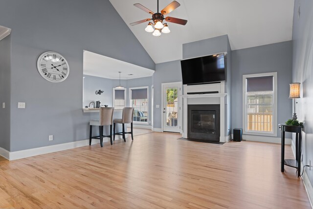 208 W Coosaw, Roebuck, SC 29376 - living room featuring baseboards, a ceiling fan, a fireplace with flush hearth, high vaulted ceiling, and light wood finished floors