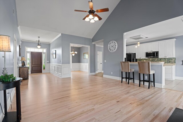 208 W Coosaw, Roebuck, SC 29376 - living area featuring light wood-style flooring, ceiling fan with notable chandelier, high vaulted ceiling, and ornamental molding