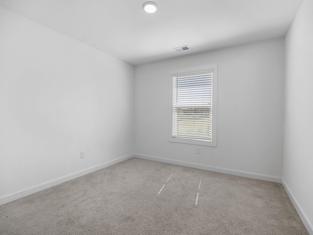unfurnished room with visible vents, baseboards, and light colored carpet