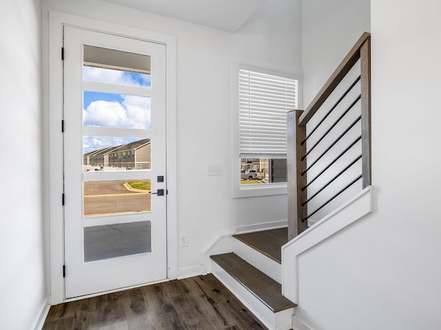interior space featuring baseboards, stairs, and dark wood-type flooring