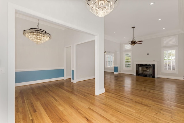 6 Pepper Bush, Greer, SC 29651 - unfurnished living room featuring light wood-type flooring, baseboards, ceiling fan with notable chandelier, crown molding, and a fireplace
