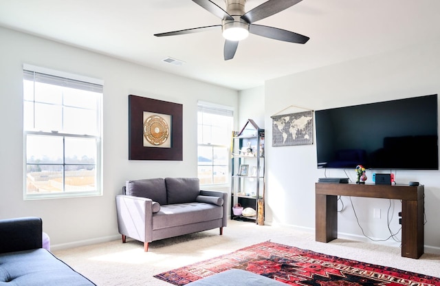 carpeted living area with visible vents, a ceiling fan, and baseboards