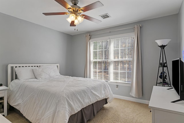 bedroom with ceiling fan, visible vents, baseboards, and light carpet
