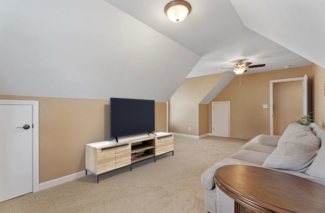 living room featuring ceiling fan, carpet floors, vaulted ceiling, and baseboards