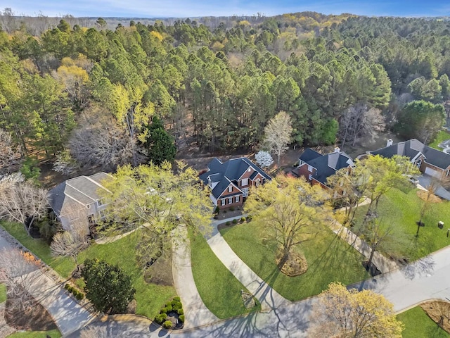 bird's eye view with a wooded view