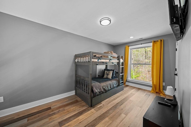 bedroom with recessed lighting, wood finished floors, and baseboards