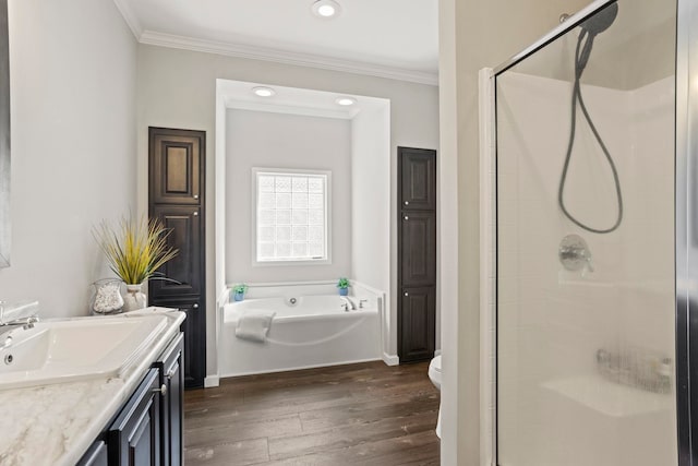 bathroom featuring crown molding, a bath, wood finished floors, and a stall shower
