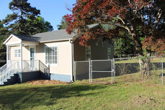 view of front of house with a gate, crawl space, a shingled roof, fence, and a front yard