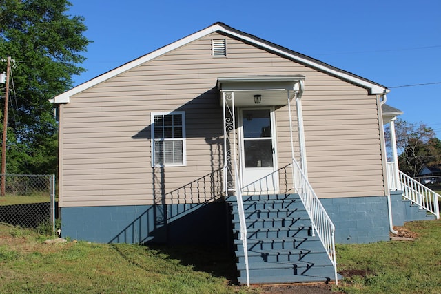 exterior space featuring a front yard, stairs, and fence