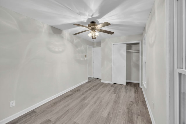 unfurnished bedroom with baseboards, wood finished floors, a closet, and ceiling fan