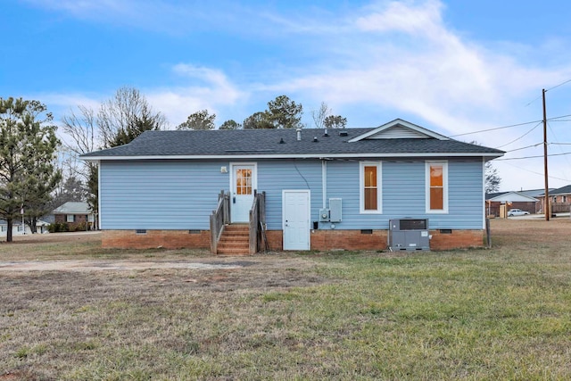 back of house featuring a lawn, crawl space, central air condition unit, and a shingled roof