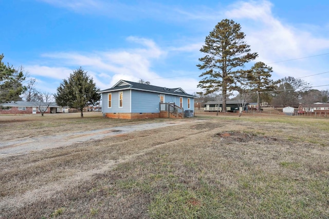 view of side of property featuring a lawn and crawl space
