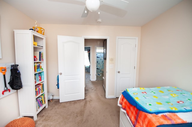 bedroom with ceiling fan, light carpet, and baseboards