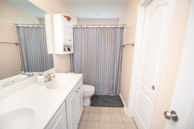full bath featuring toilet, a sink, and double vanity