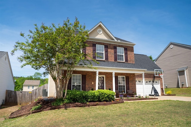 traditional-style home with brick siding, concrete driveway, a front yard, and fence
