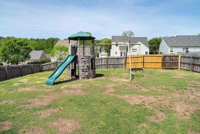 view of playground with a lawn, a fenced backyard, and a residential view